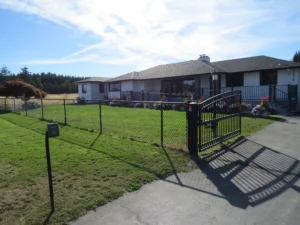 Fenced front yard and gated driveway of the home