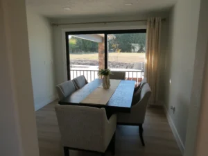 Dining table with seating for residents beside a sliding glass door overlooking the countryside