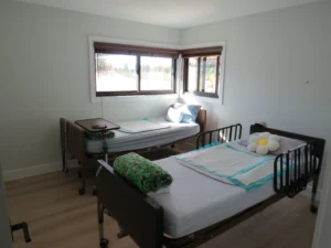 Shared resident bedroom with two care beds and corner windows